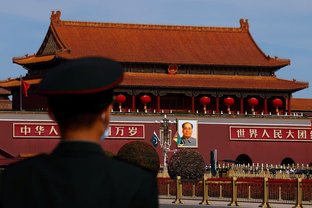 A Chinese security officer stands before Tiananmen Gate in Beijing as China enforces its new ethnic unity law amid concerns over minority rights, Uighurs and Tibetans.