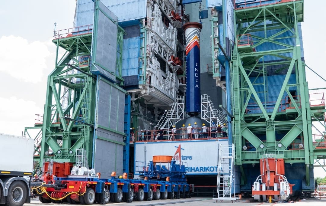 ISRO launch vehicle stands on the launch pad at Sriharikota ahead of a mission, surrounded by launch infrastructure and support equipment.