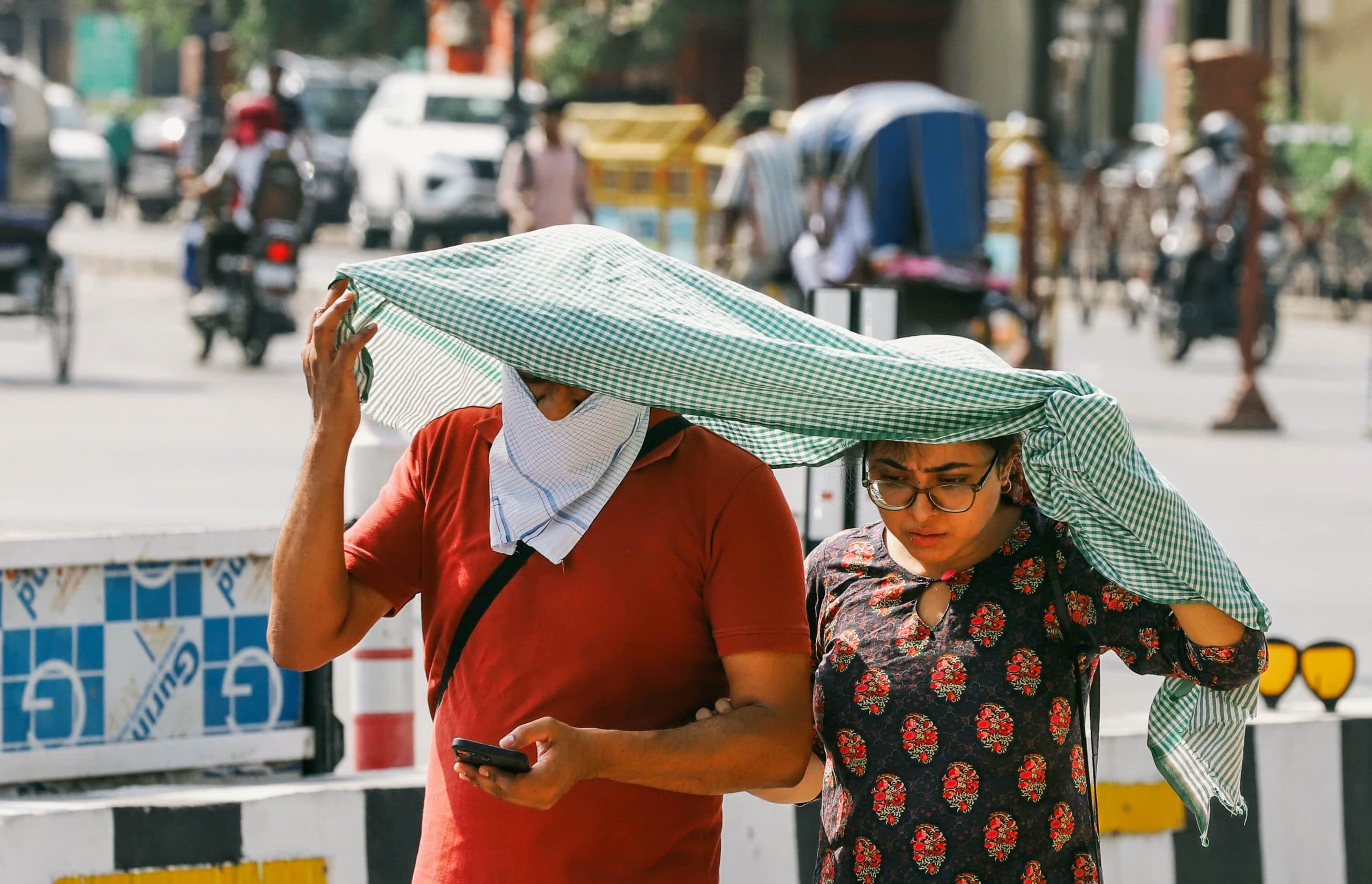 People use a cloth and scarf to shield themselves from the scorching heat on a hot summer day