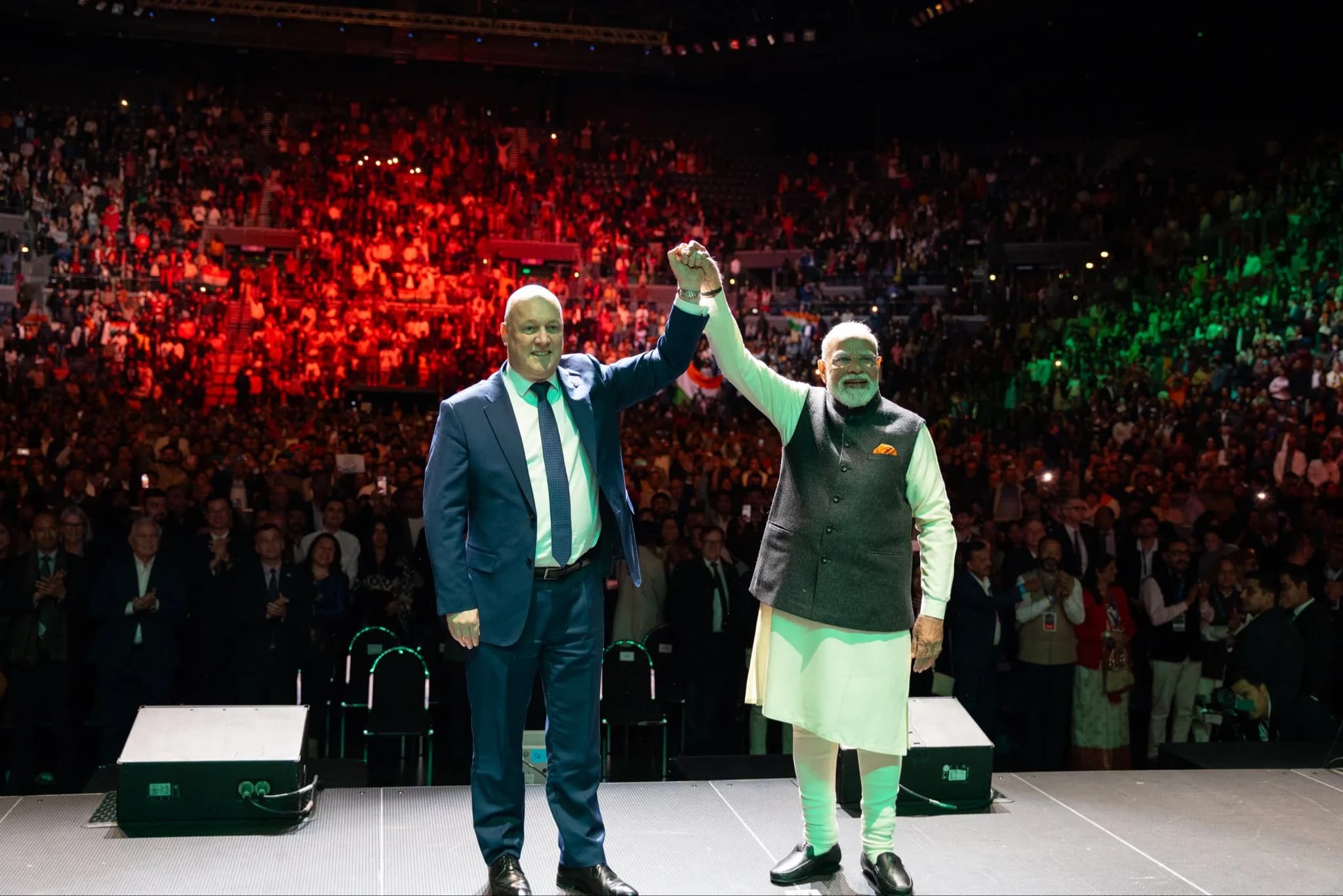 Prime Minister Narendra Modi and New Zealand Prime Minister Christopher Luxon raise their joined hands during an event in Auckland.