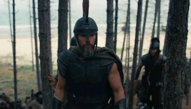 Christopher Nolan's The Odyssey cast filming against a dramatic coastal landscape inspired by ancient Greece.