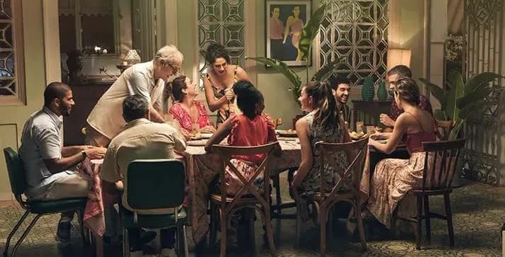 Parents and two children enjoying a screen-free family dinner while talking and smiling around the dining table.